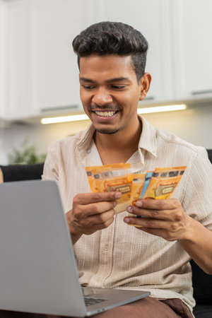 Man at home checks euro cash with laptop spreadsheet enters sums checks total for salary and bonus....