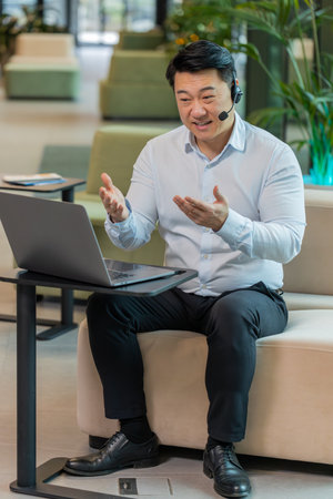 Chinese businessman wearing headset, call center or support service operator helpline, having talk...