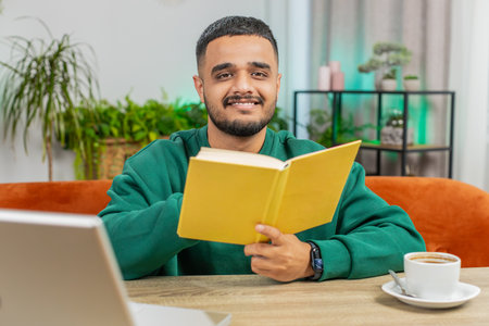 Man reading interesting book, turning pages smiling enjoying literature, taking a rest on...