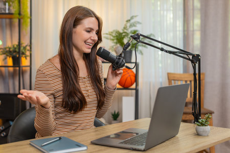Young woman at home records vlog speaks to studio microphone gives greeting and short intro about...
