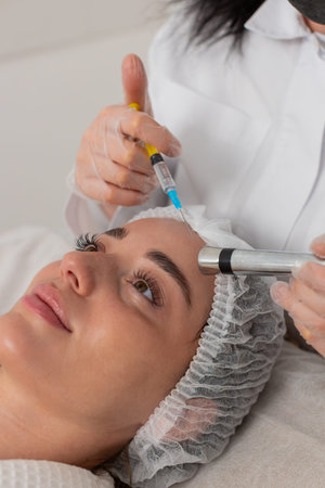 Caucasian woman girl receives non-invasive face rejuvenation during electroporation procedure....