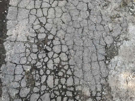 background texture plot of old city road smashed by car wheels into set small pieces of grey with...