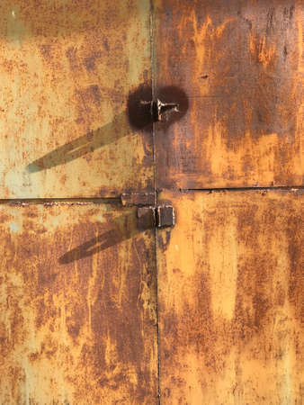 old garage gate made of metal with rust and seams from welding.