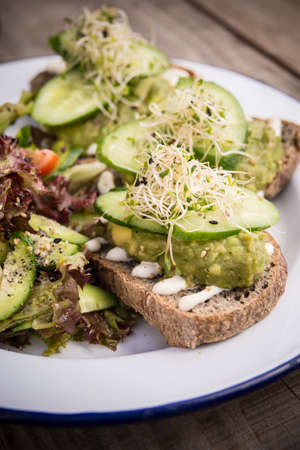 Avocado and cucumber sandwich on a piece of ray bread, side view