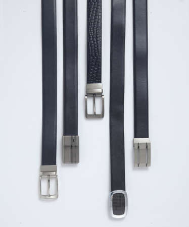 Bunch of men's belts, group of leather belts for man, isolated. View of different leather belts with...
