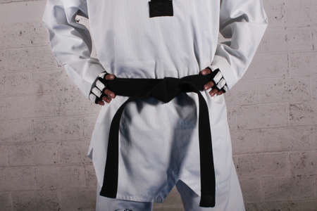 taekwondo player wearing white dobok and protection gloves in stance positionの写真素材