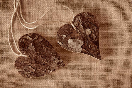 Two wooden hearts on brown textile の写真素材