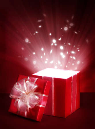 Open magic gift box on red backgroundの写真素材