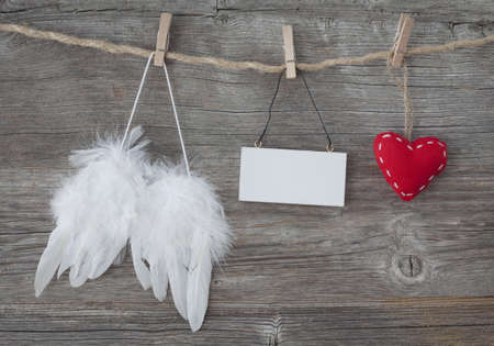 Angel wings with heart and blank note on grey wooden backgroundの写真素材