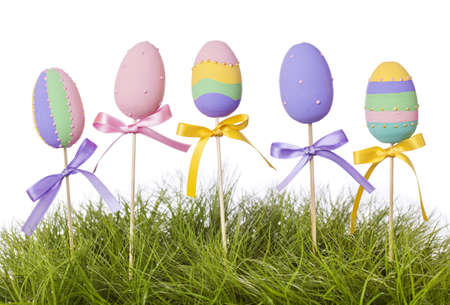 Easter eggs on wooden sticks and green grassの写真素材
