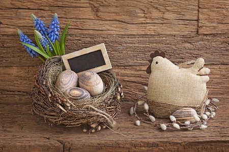 Easter eggs in nest and flowers  on wooden backgroundの写真素材