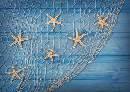 Seastars on the fishing net on a blue backgroundの写真素材