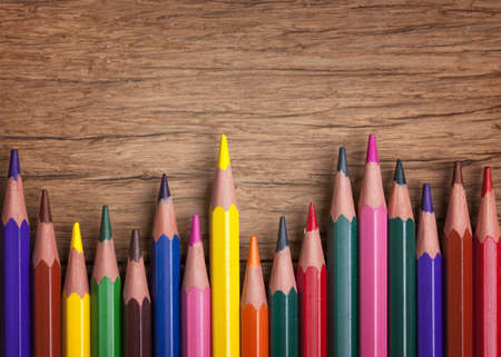 Colorful pencils on a wooden background