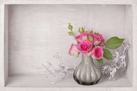 Pink roses in a vase on blue backgroundの写真素材