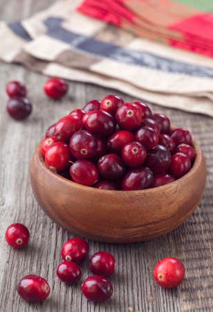 Cranberries in a bowl on wooden tableの写真素材