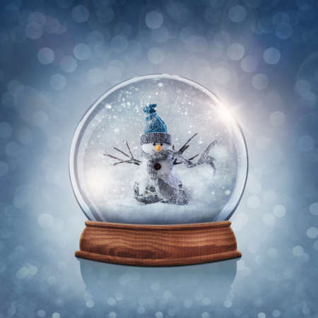 Snow globe with snowman on a blue backgroundの写真素材
