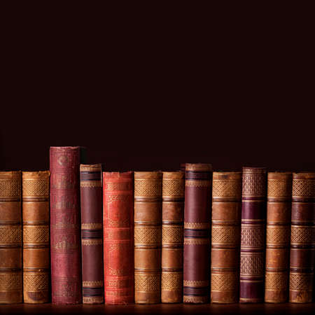 Old vintage books standing in a rowの写真素材