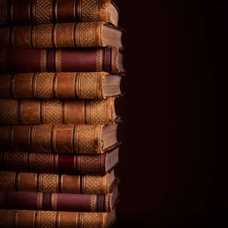 Pile of ancient books on brown backgroundの写真素材