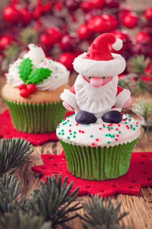 Christmas cup cakes with santa and holly berryの写真素材