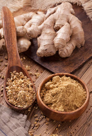 Ginger fresh root and ginger spice on a wooden table