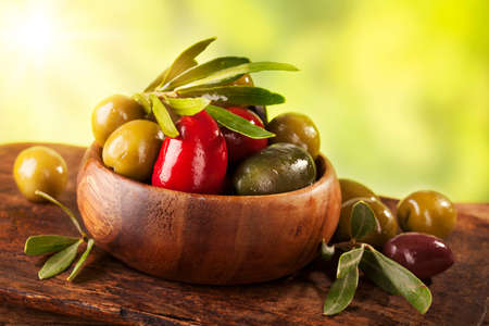 Bowl with mixed olives on a wooden tableの写真素材