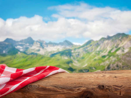 Empty wooden table with red napkins over nature backgroundの写真素材