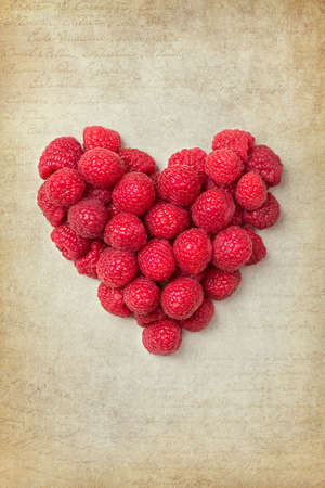 Heart from raspberries on a vintage background