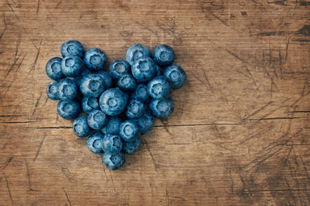 Heart from blackberries on a wooden backgroundの写真素材