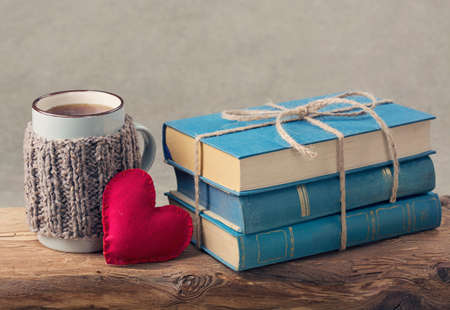 Pile of old blue books and a cup of teaの写真素材