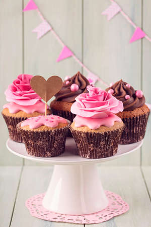 Cupcakes with sweet rose flowers and a cakepick for textの写真素材