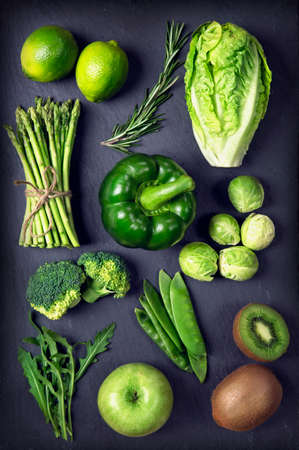 Green healphy vegetables and fruits on a black slatesの写真素材