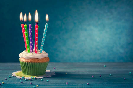 Cupcake with candles on a blue wooden backgroundの写真素材