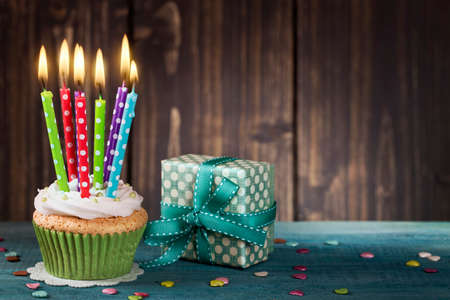 Cupcake with birthday candle and gift boxの写真素材