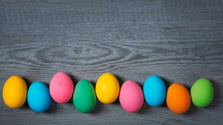 Easter eggs hanging on a wooden background