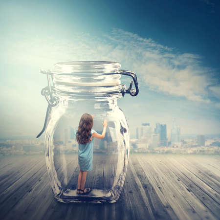 Young girl standing in a glass jarの写真素材