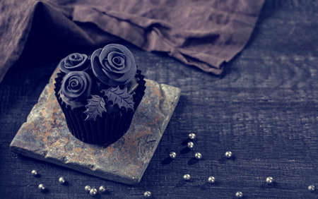 Black cupcakes on a dark wooden backgroundの写真素材
