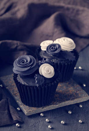 Black cupcakes on a dark wooden backgroundの写真素材