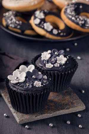 Black cupcakes on a dark wooden backgroundの写真素材
