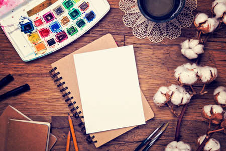 Artistic workplace mock up with watercolor paper and painting suppliesの写真素材