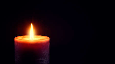 Burning candle on a black backgroundの写真素材