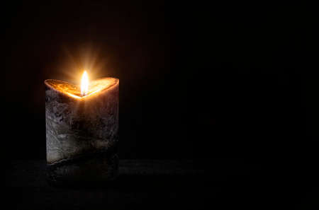 Burning candle on a black backgroundの写真素材