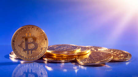 Gold bitcoins on a blue backgroundの写真素材