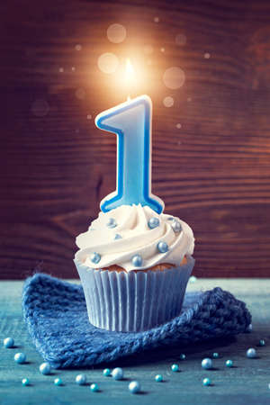 Cupcake with a blue candle for first birthdayの写真素材