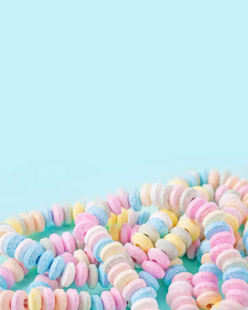 Candy necklace on a blue pastel colored background