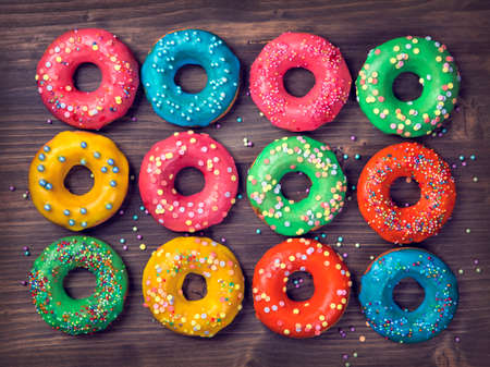 Colorful donuts on a wooden brown backgroundの写真素材