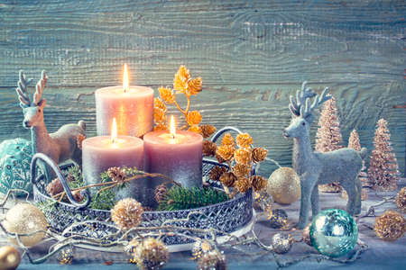 Candles and christmas decoration on a wooden backgroundの写真素材