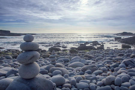 Pyramid of pebbles on the sea front の写真素材