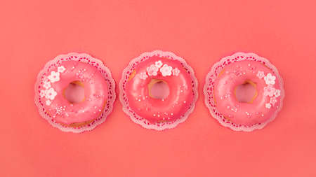 Sweet donuts on a living coral paper backgroundの写真素材