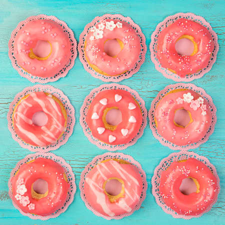 Coral colored donuts on a blue wooden backgroundの写真素材