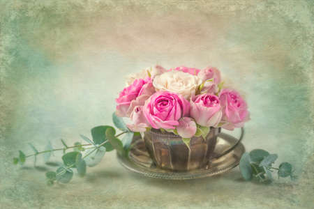 Pink roses in a teacup. Textured backgroundの写真素材